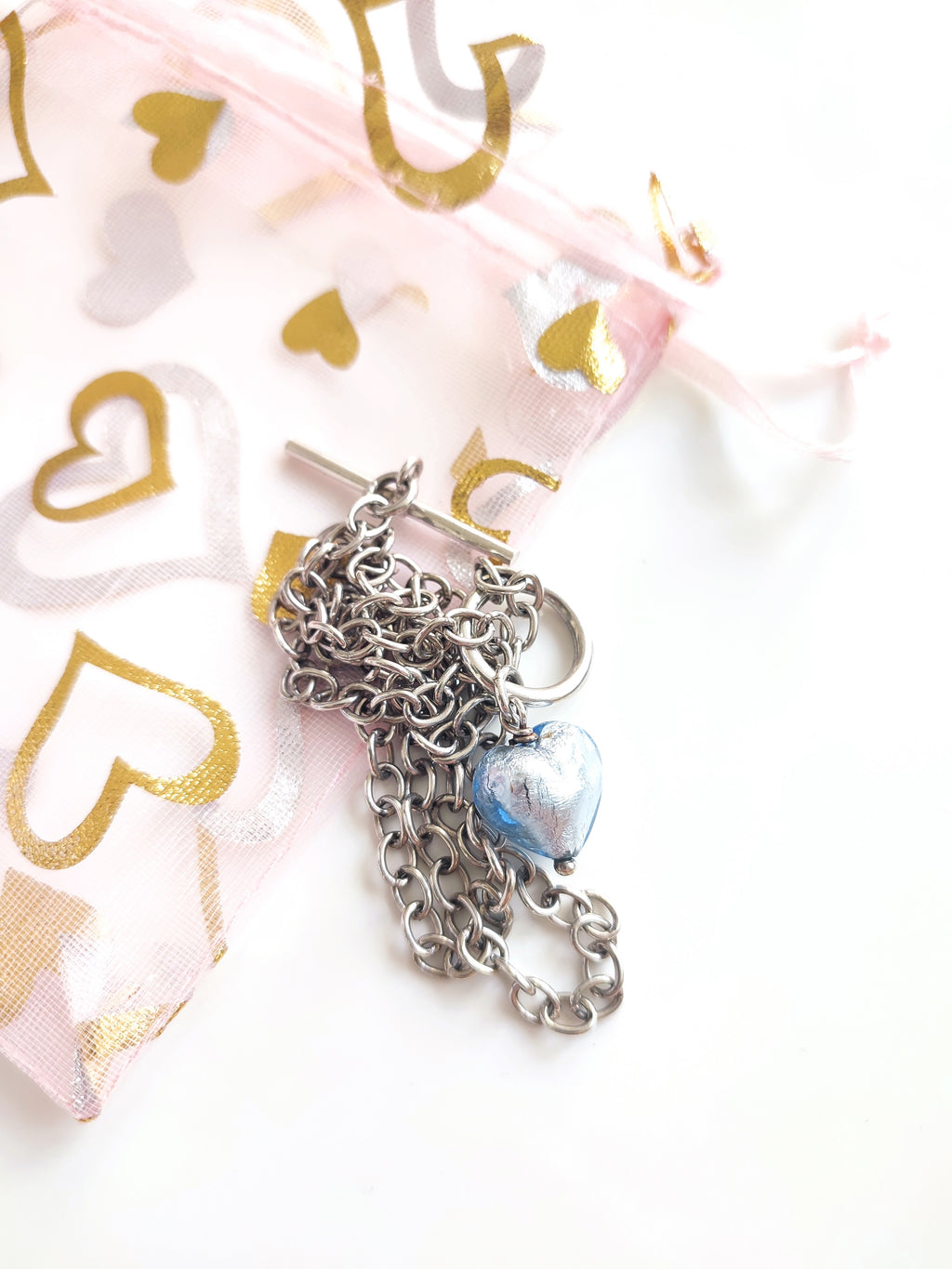 A silver necklace with blue glass heart