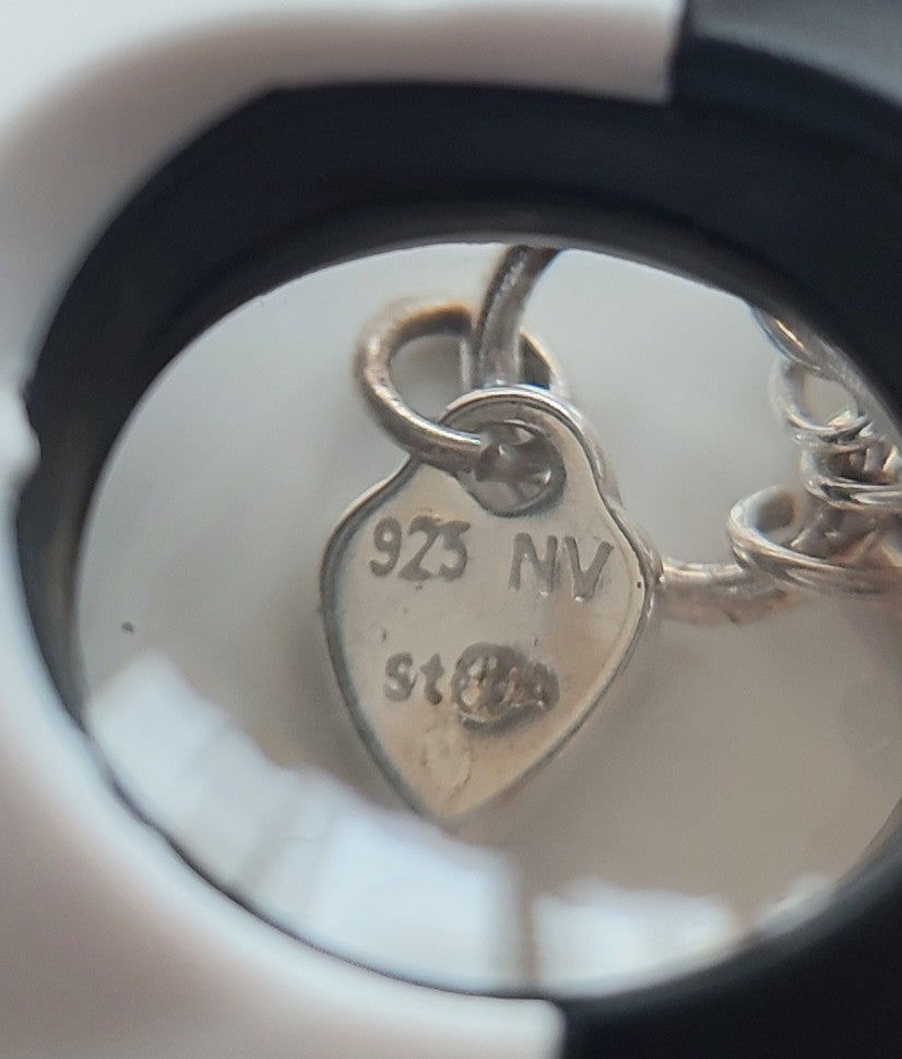 A silver necklace with blue glass heart